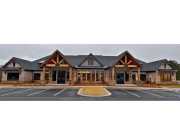 Front elevation with timber trusses and stone facade at Reliant Homes office