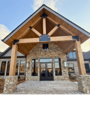 Close-up of timber entry structure with stone base and modern lighting