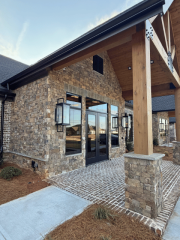 Close-up of timber entry structure with stone base and modern lighting