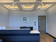 Reception desk with Reliant Homes logo and modern lighting