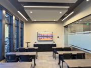 Office training classroom with desks, large windows, and modern lighting