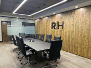 Conference room with wood accent wall, glass partitions, and modern table