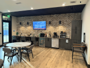 Office kitchen with dark cabinetry, seating area, and modern finishes